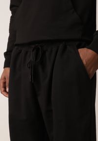 Born2be - Czarne Spodnie Dresowe z Bawełną ze Ściągaczami Hailise. Okazja: na co dzień, do domu. Kolor: czarny. Materiał: bawełna, dresówka. Styl: casual, sportowy #8