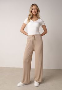 Born2be - Beżowe Szerokie Spodnie z Bawełną Zdobione Cyrkoniami Azilene. Okazja: na co dzień. Stan: podwyższony. Kolor: beżowy. Materiał: bawełna. Wzór: aplikacja. Styl: casual, klasyczny #1