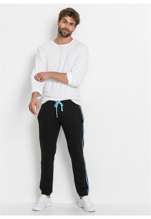 bonprix - Spodnie sportowe z kontrastowymi elementami. Kolor: czarny. Materiał: dresówka. Styl: sportowy