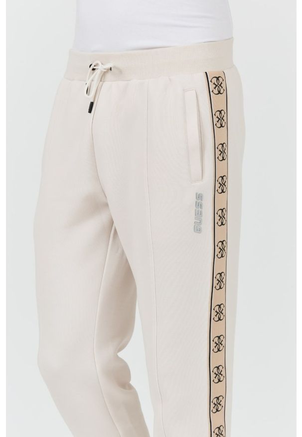 Guess - GUESS Beżowe spodnie Mickey Cuff Pant. Kolor: beżowy