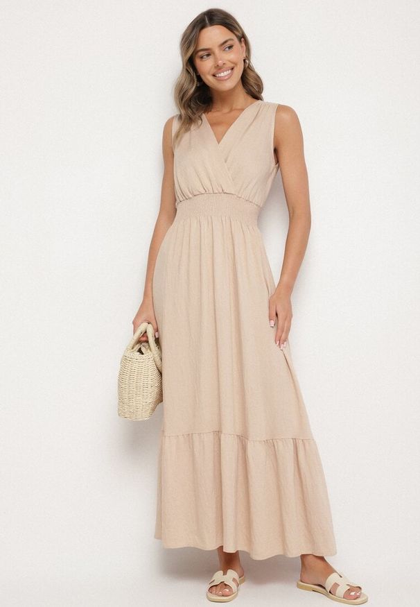 Born2be - Beżowa Kopertowa Sukienka z Wiskozy Bez Rękawów Nalimira. Okazja: na co dzień, na spotkanie biznesowe. Typ kołnierza: dekolt w serek. Kolor: beżowy. Materiał: wiskoza. Długość rękawa: bez rękawów. Typ sukienki: kopertowe. Styl: casual, klasyczny, biznesowy