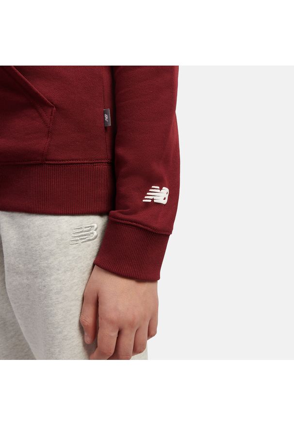 Bluza dziecięca New Balance LAKB0347MHB – bordowa. Typ kołnierza: kaptur. Kolor: czerwony. Materiał: bawełna. Wzór: napisy, aplikacja. Styl: sportowy