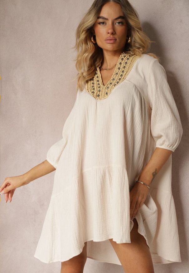 Renee - Beżowa Rozkloszowana Sukienka Mini Ozdobiona Plecionką Przy Dekolcie Rufta. Kolor: beżowy. Wzór: aplikacja. Sezon: lato. Typ sukienki: rozkloszowane. Styl: boho. Długość: mini