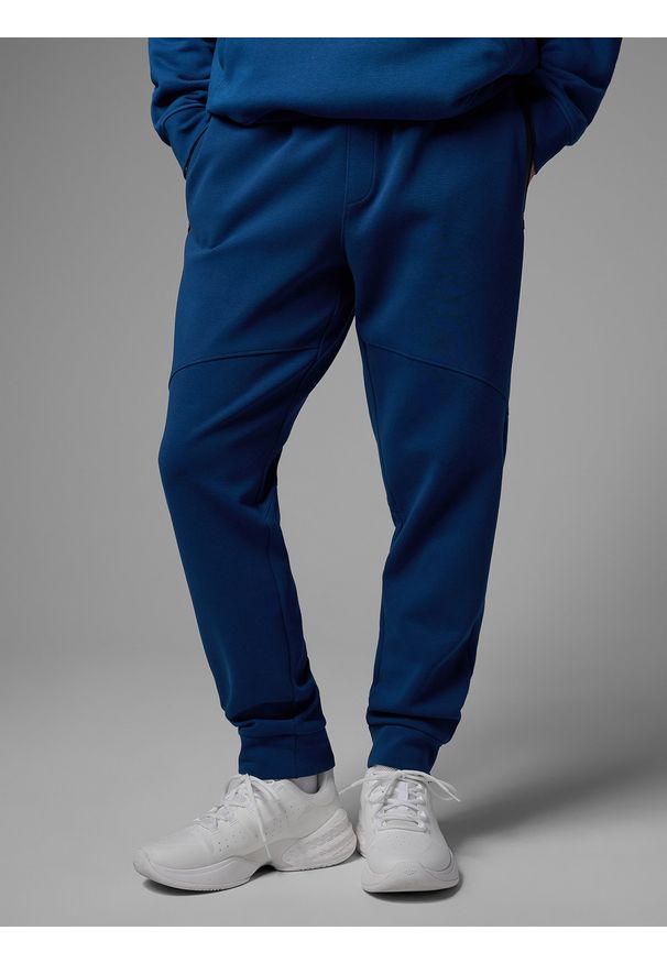 4f - 4F Spodnie dresowe joggery męskie 4F x Robert Lewandowski - granatowe XL. Kolor: niebieski. Materiał: dresówka. Wzór: nadruk. Sport: piłka nożna