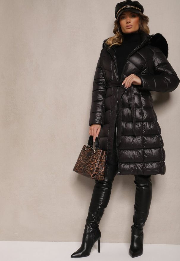 Renee - Czarna Długa Kurtka Pikowana z Odpinanym Kapturem Ozdobionym Futerkiem i Paskiem Iveleti. Okazja: na co dzień. Kolor: czarny. Materiał: futro. Długość: długie. Wzór: aplikacja. Styl: casual, elegancki