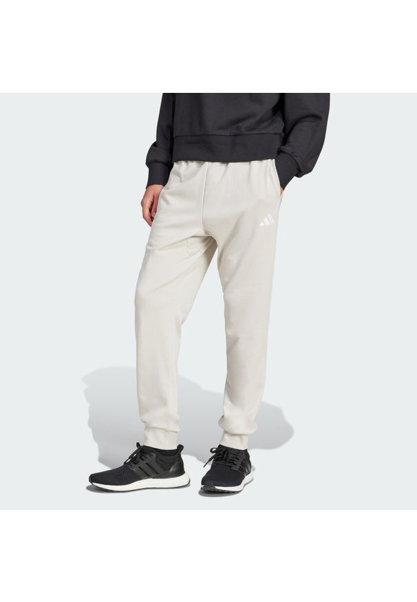 Adidas - Spodnie Essentials Feel Cozy French Terry. Kolor: biały, beżowy, wielokolorowy. Materiał: materiał, dresówka. Sport: fitness