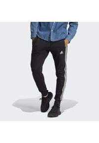 Adidas - Essentials French Terry Tapered Cuff 3-Stripes Pants. Kolor: biały, wielokolorowy, czarny. Materiał: dresówka