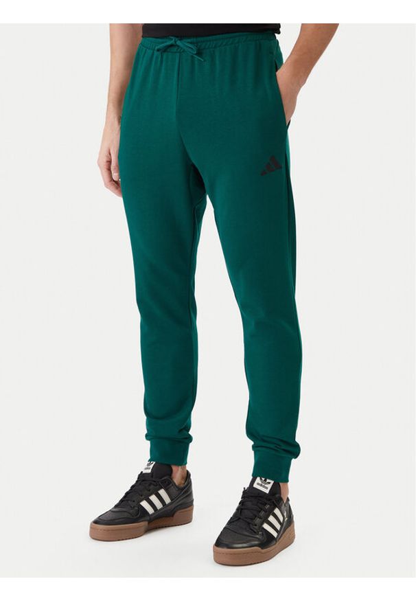 Adidas - adidas Spodnie dresowe Essentials Feel Cozy JE3858 Zielony Regular Fit. Kolor: zielony. Materiał: bawełna