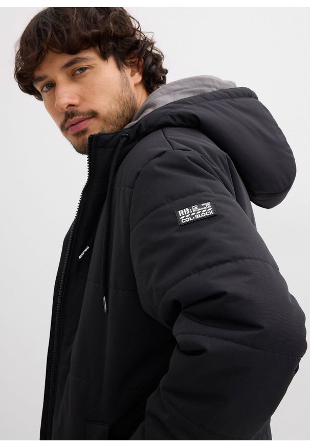 bonprix - Zimowa kurtka pikowana o kroju bomberki z kapturem. Typ kołnierza: kaptur. Kolor: czarny. Sezon: zima