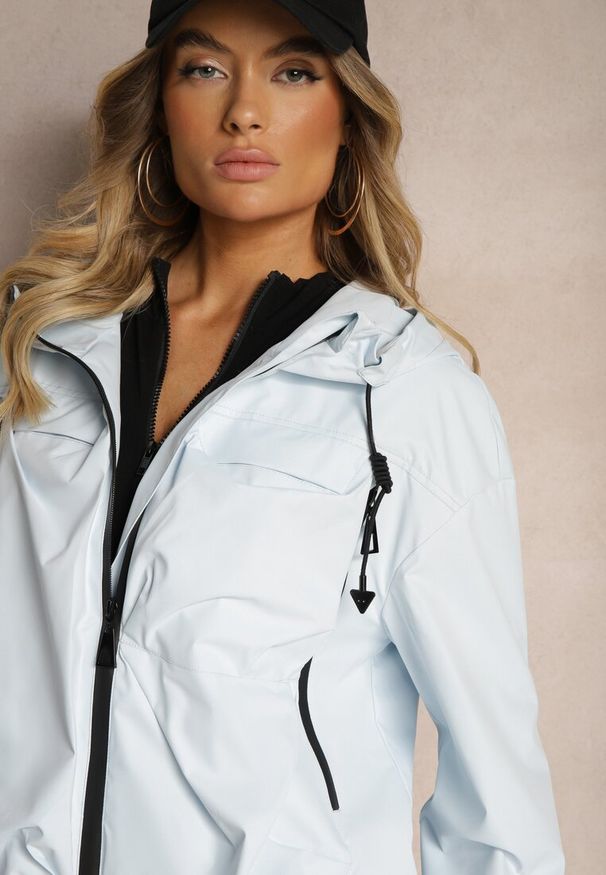 Renee - Jasnoniebieska Kurtka o Fasonie Wiatrówki Ozdobiona Kieszeniami Bralisa. Okazja: na co dzień, na spacer. Kolor: niebieski. Wzór: aplikacja. Styl: sportowy, elegancki, casual