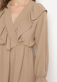 Born2be - Ciemnobeżowa Rozkloszowana Sukienka o Kopertowym Kroju z Falbankami Celonara. Okazja: na imprezę. Typ kołnierza: kołnierz z falbankami. Kolor: beżowy. Typ sukienki: kopertowe. Styl: elegancki #5