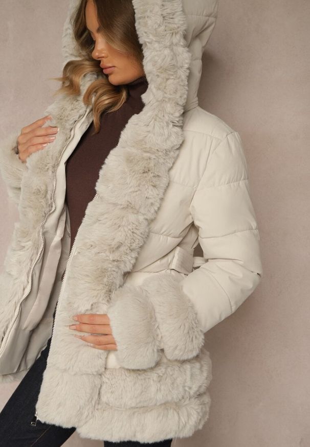 Renee - Jasnobeżowa Kurtka o Taliowanym Kroju z Paskiem Kapturem i Futerkiem Ranalia. Typ kołnierza: golf. Kolor: beżowy. Materiał: futro. Sezon: zima