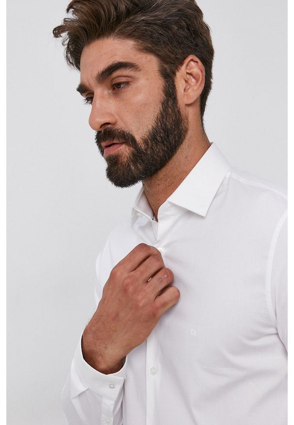 Calvin Klein koszula męska kolor biały slim z kołnierzykiem klasycznym. Typ kołnierza: kołnierzyk klasyczny. Kolor: biały. Materiał: tkanina, bawełna. Długość rękawa: długi rękaw. Długość: długie. Wzór: gładki. Styl: klasyczny