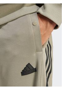 Adidas - adidas Spodnie dresowe Tiro IS1504 Zielony Regular Fit. Kolor: zielony. Materiał: bawełna