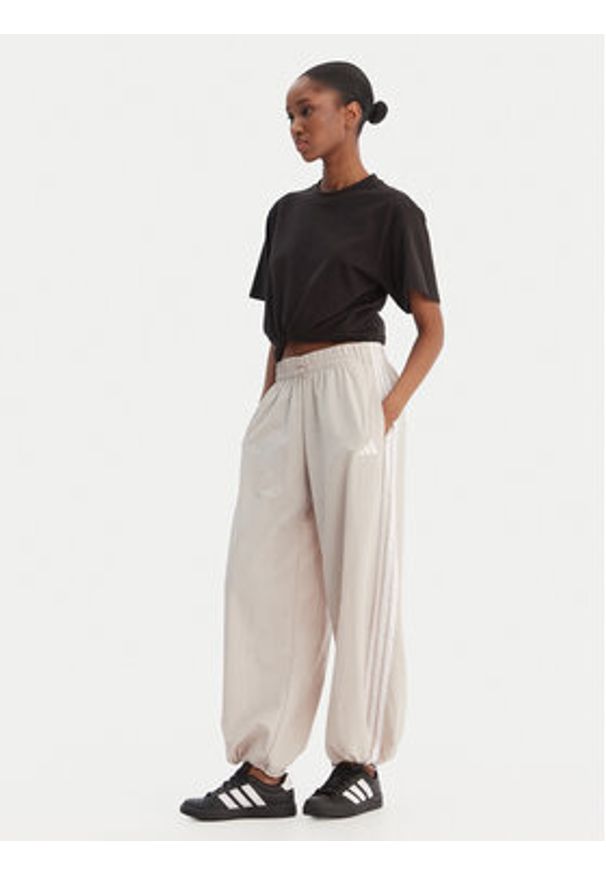 Adidas - adidas Spodnie dresowe Essentials 3-Stripes JC8168 Beżowy Loose Fit. Kolor: beżowy. Materiał: syntetyk