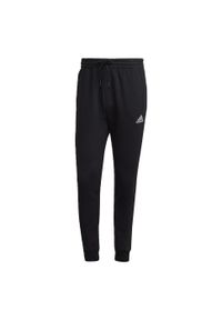 Adidas - Essentials Fleece Regular Tapered Pants. Kolor: biały, czarny, wielokolorowy. Materiał: materiał