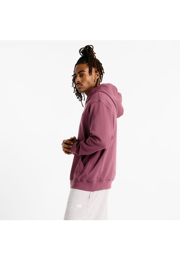Bluza męska New Balance MT41534FDP – fioletowa. Typ kołnierza: kaptur. Kolor: fioletowy. Materiał: bawełna, prążkowany. Wzór: haft