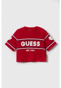 Guess t-shirt bawełniany dziecięcy kolor czerwony. Okazja: na co dzień. Kolor: czerwony. Materiał: bawełna. Długość rękawa: krótki rękaw. Długość: krótkie. Styl: casual, klasyczny