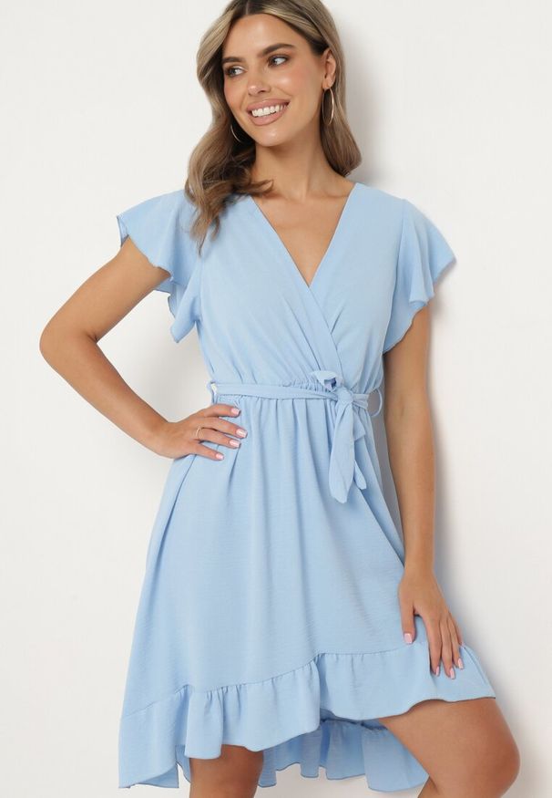 Born2be - Jasnoniebieska Kopertowa Sukienka z Asymetrycznym Dołem Ozdobiona Falbanką z Paskiem w Talii Snidia. Okazja: na spacer, na co dzień. Kolor: niebieski. Wzór: aplikacja. Sezon: lato. Typ sukienki: kopertowe, asymetryczne. Styl: elegancki, casual, klasyczny
