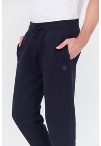 Guess - GUESS Granatowe spodnie dresowe Aldwin. Kolor: niebieski. Materiał: dresówka