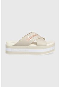 Calvin Klein Jeans klapki skórzane damskie kolor beżowy na platformie. Kolor: beżowy. Materiał: skóra. Wzór: nadruk. Obcas: na platformie #1