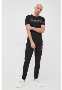Calvin Klein spodnie bawełniane męskie kolor czarny z nadrukiem. Kolor: czarny. Materiał: bawełna. Wzór: nadruk