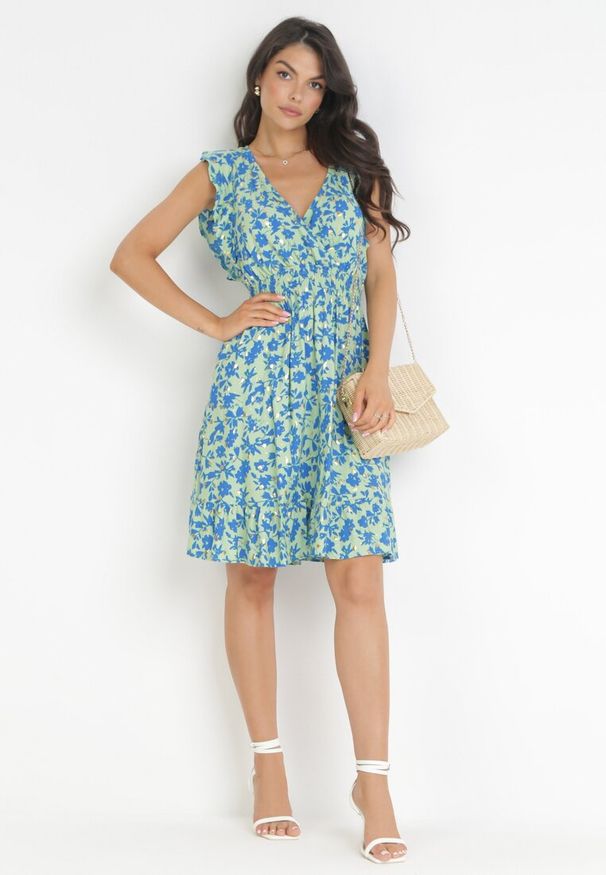 Born2be - Jasnozielona Rozkloszowana Sukienka z Wiskozy Ozdobiona Metalicznym Nadrukiem Elulaia. Typ kołnierza: kołnierz z falbankami. Kolor: zielony. Materiał: wiskoza. Wzór: nadruk, aplikacja. Typ sukienki: kopertowe