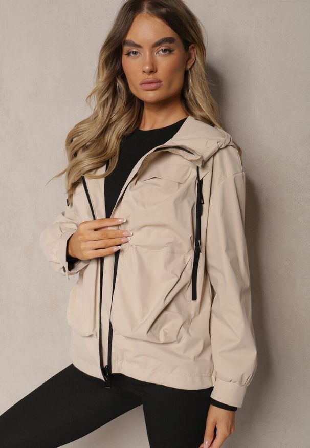 Renee - Beżowa Kurtka o Fasonie Wiatrówki Ozdobiona Kieszeniami Bralisa. Okazja: na co dzień, na spacer. Kolor: beżowy. Wzór: aplikacja. Styl: sportowy, elegancki, casual