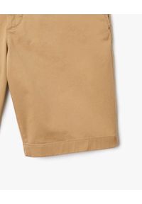 Lacoste - LACOSTE - Beżowe bawełniane bermudy Slim Fit. Kolor: beżowy. Materiał: bawełna