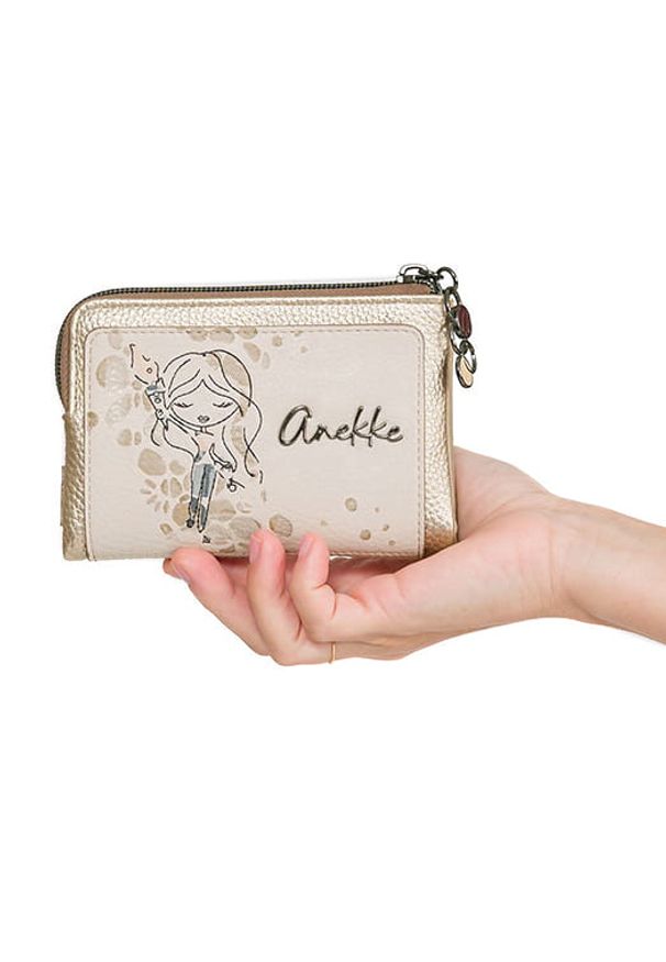 Portfel damski Anekke, z ozdobnym nadrukiem i metalowym logo zapinany na suwak wyposażony w przegrody na karty kieszeń na monety oraz miejsce na bank. Kolor: złoty. Wzór: nadruk