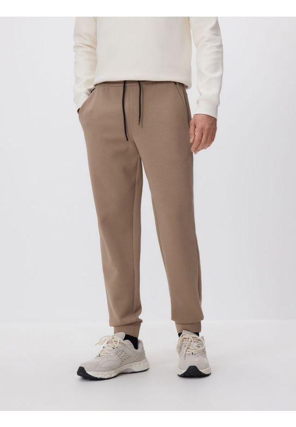 Reserved - Spodnie dresowe slim fit - beżowy. Kolor: beżowy. Materiał: dresówka
