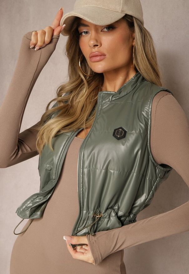 Renee - Ciemnozielona Kamizelka o Krótkim Kroju ze Ściągaczem w Talii i Naszywką Mevannae. Okazja: na spotkanie biznesowe. Kolor: zielony. Materiał: jeans. Długość: krótkie. Wzór: aplikacja. Styl: biznesowy, elegancki