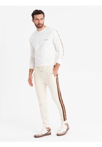 Ombre Clothing - Dresowe męskie spodnie z lampasami i ściągaczami na nogawkach – kremowe V3 OM-PASK-0258 - XXL. Kolor: kremowy. Materiał: dresówka. Wzór: aplikacja, kolorowy. Styl: retro, elegancki