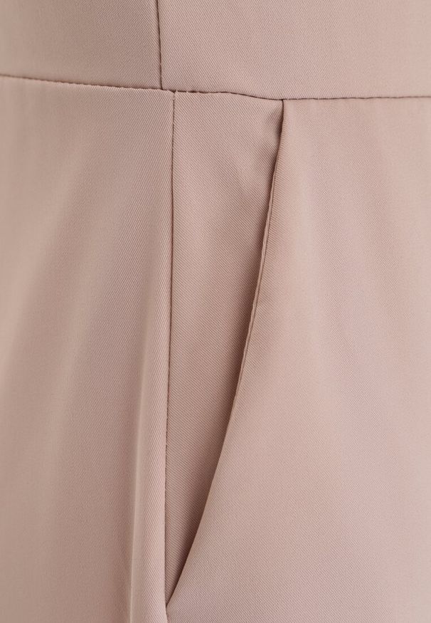 Renee - Beżowy Taliowany Kombinezon Ozdobiony Zakładkami Berinola. Okazja: na imprezę. Kolor: beżowy. Wzór: aplikacja. Styl: elegancki