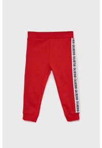 Guess - Spodnie bawełniane dziecięce. Okazja: na co dzień. Kolor: czerwony. Materiał: bawełna. Styl: casual