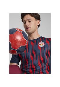 Puma - Męska koszulka przedmeczowa z krótkim rękawem FC Red Bull Salzburg PUMA. Kolor: czerwony, wielokolorowy, niebieski. Długość rękawa: krótki rękaw. Długość: krótkie
