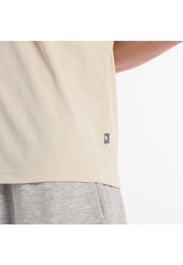 Koszulka męska New Balance MT51507TWF – beżowa. Kolor: beżowy. Materiał: bawełna, dresówka. Wzór: aplikacja, napisy