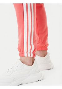Adidas - adidas Spodnie dresowe Essentials 3-Stripes KE4387 Koralowy Regular Fit. Kolor: pomarańczowy. Materiał: bawełna #4