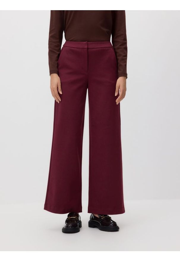 Reserved - Luźne spodnie - bordowy. Kolor: czerwony. Materiał: dzianina. Wzór: gładki