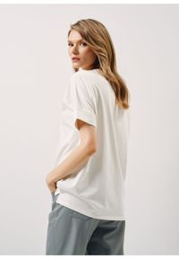 Ochnik - Kremowy T-shirt damski z kwiatowym printem. Kolor: biały. Materiał: bawełna. Wzór: nadruk, kwiaty