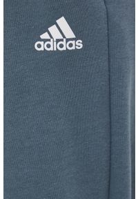 Adidas - adidas spodnie HD6806 damskie gładkie. Kolor: niebieski. Materiał: bawełna, dzianina. Wzór: gładki