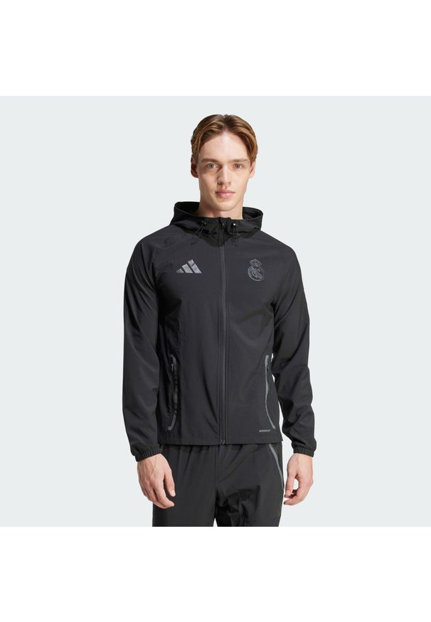 Adidas - Real Madrid Tiro 25 Competition Vis Tech Travel Jacket. Kolor: czarny. Materiał: materiał. Sport: piłka nożna