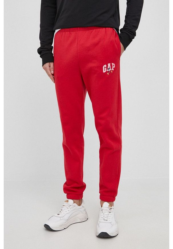 GAP spodnie x Disney męskie kolor czerwony z nadrukiem. Kolor: czerwony. Wzór: nadruk, motyw z bajki