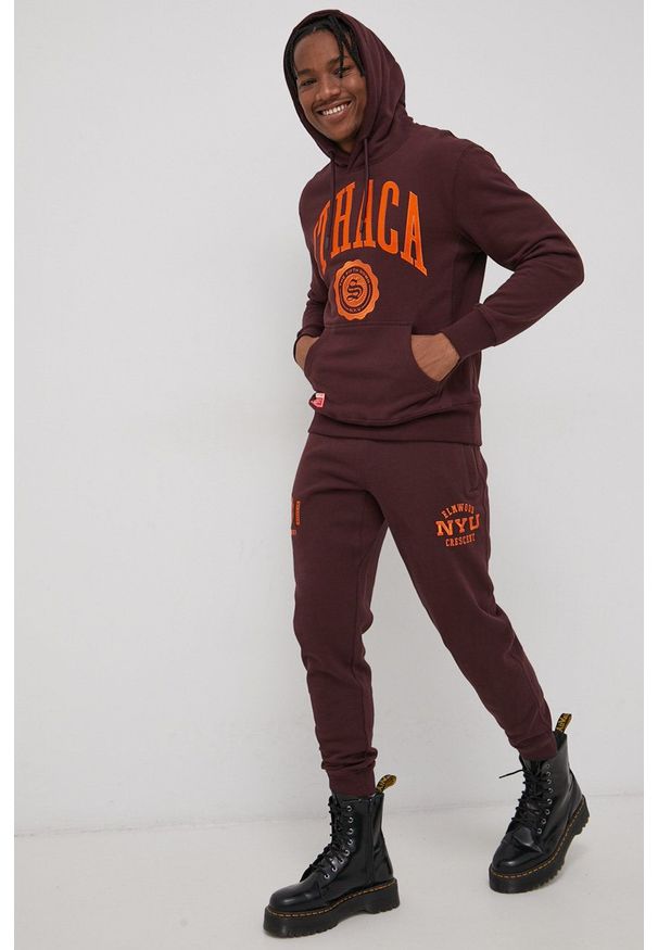 Superdry Bluza bawełniana męska kolor bordowy z kapturem z aplikacją. Typ kołnierza: kaptur. Kolor: czerwony. Materiał: bawełna. Wzór: aplikacja