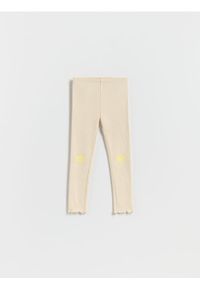 Reserved - Prążkowane legginsy z nadrukiem - beżowy. Kolor: beżowy. Materiał: prążkowany. Wzór: nadruk