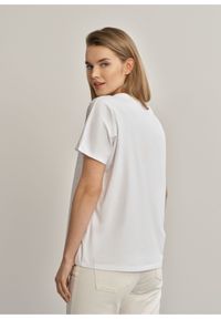 Ochnik - Biały T-shirt damski z cekinami. Typ kołnierza: dekolt w serek. Kolor: biały. Materiał: bawełna. Długość rękawa: krótki rękaw. Długość: krótkie. Wzór: aplikacja