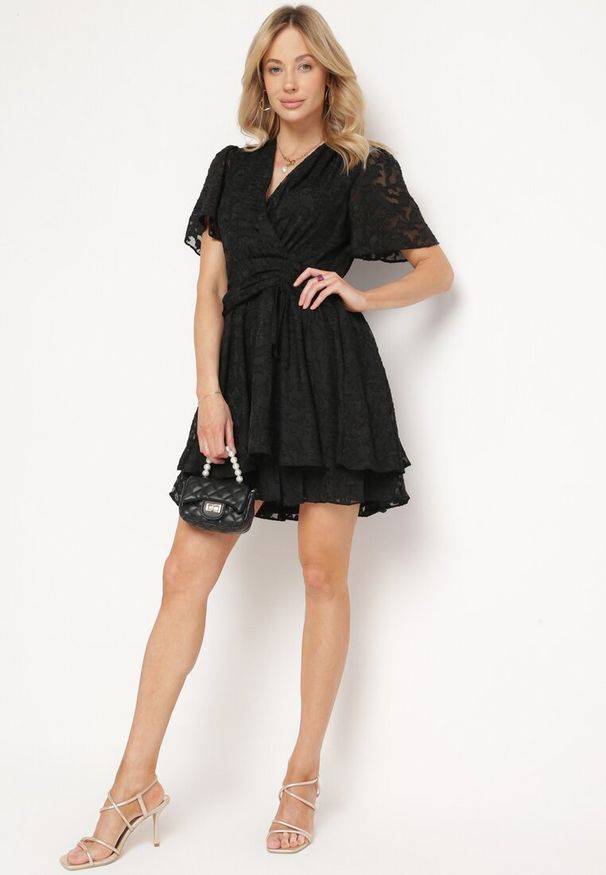 Born2be - Czarna Sukienka o Rozkloszowanym Kroju z Dekoltem Zapinanym na Napy Uzimira. Okazja: do pracy. Typ kołnierza: dekolt w kształcie V. Kolor: czarny. Styl: klasyczny