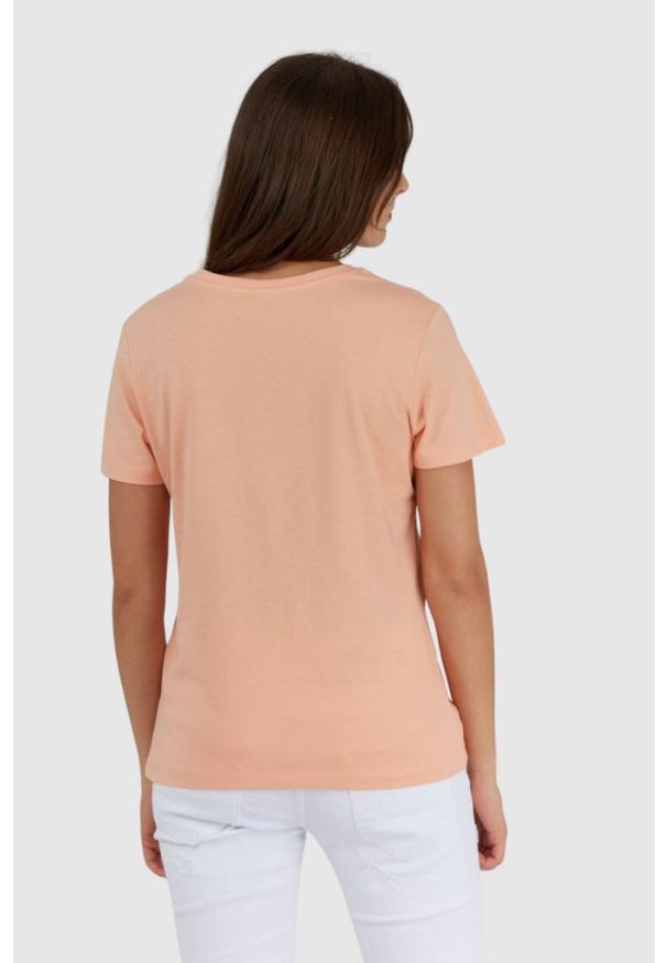 Guess - GUESS Brzoskwiniowy t-shirt damski z białym logo. Kolor: pomarańczowy. Materiał: bawełna. Wzór: nadruk