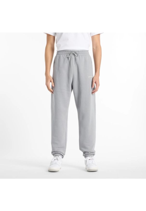 Spodnie męskie New Balance MP51505YST – szare. Kolor: szary. Materiał: dresówka, bawełna, materiał, poliester. Wzór: napisy