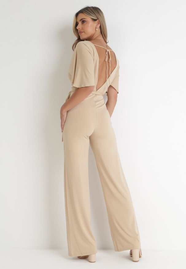 Born2be - Beżowy Długi Kombinezon z Kopertowym Dekoltem i Ozdobnym Wiązaniem Abrarani. Okazja: na spotkanie biznesowe. Kolor: beżowy. Długość: długie. Styl: elegancki, biznesowy